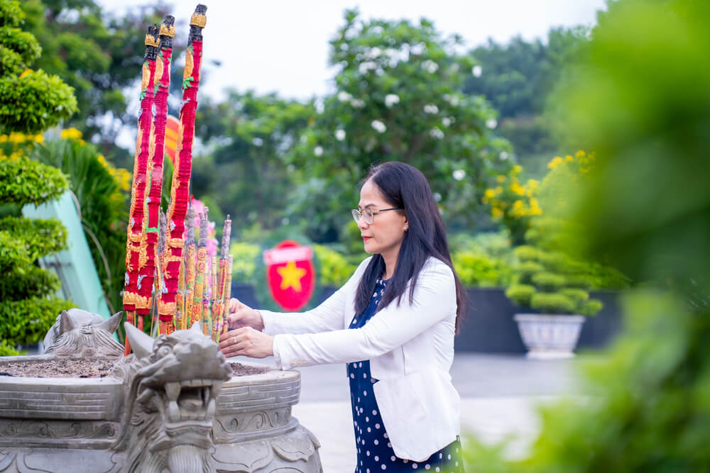 Hiệu trưởng Ngô Thị Quỳnh Xuân thắp nhang tại Nghĩa trang Liệt sĩ Thành phố